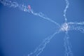Star-shaped smoke jets and a tiny skydiver on a high altitude in a blue sky. Royalty Free Stock Photo