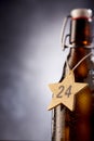 Star shaped tag with 24 December number around bottle Royalty Free Stock Photo