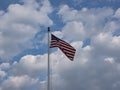 15 Star USA Flag called the Star Spangled Banner flies unfurled with cumulus clouds and blue sky in the background