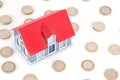 Star-studded euro coins and small house model on white background Royalty Free Stock Photo