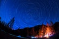 Star Trail in sky above the mountains fire in the tent camp Royalty Free Stock Photo