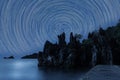 Star Trails Against rugged rocks silhouette