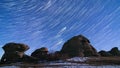 Star trails moving in the night sky above the rock remains. High quality 4k time lapse video