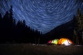 Star trails in the night sky above the tent. Time-lapse. Royalty Free Stock Photo