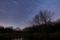 Star trails with forest and lake in the forground