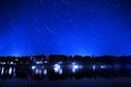 Star Trails in Night Sky of Lake and Pine Forest Wilderness Dark Light Royalty Free Stock Photo