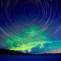 Star trails and Northern lights in night sky Royalty Free Stock Photo