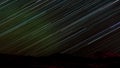 Star trails in sky over dark Yukon taiga landscape