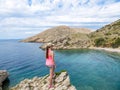 Stara Baska - A girl standing on a rock with Stara Baska Beach view