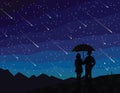 Starfall. Silhouette of couple under umbrella, watching falling stars. The starry night sky. Meteor shower.