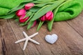 Starfish, heart and tulips on a wooden table