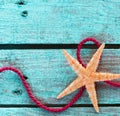 Starfish with looped rope on turquoise wood