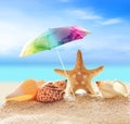 Starfish with parasol and shells on the beach Royalty Free Stock Photo