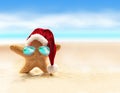 Starfish in red santa hat at the seaside. Christmas in summer. Royalty Free Stock Photo