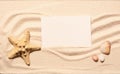 Starfish, scallop seashell, stones with white card on beach sand