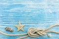 Starfish, sea stones and rope on blue rustic wooden background Royalty Free Stock Photo