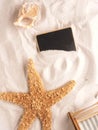 Starfish and shell with small tablet in sandy beach Royalty Free Stock Photo