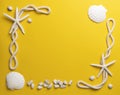 Starfish, shells, stones and rope on a plain yellow background Royalty Free Stock Photo