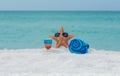 Starfish , towel and cocktail on white sand tropical beach Royalty Free Stock Photo