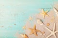 Starfishes and seashells on sand for summer holidays and travel background