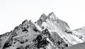 Jagged snow covered mountain peaks against white sky 1 Royalty Free Stock Photo