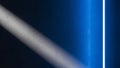 Stark blue light illuminates textured concrete wall with diagonal shadow Royalty Free Stock Photo