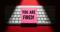 You Are Fired Pink Sticky Note on Computer Keyboard with Dramatic Lighting Business Termination Concept Royalty Free Stock Photo
