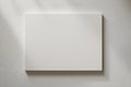A stark white square canvas hangs on a lightly textured neutral wall Royalty Free Stock Photo