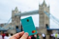 Starling Bank card hold in hand and London Tower Bridge at the blurred background