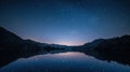 Starry night over tranquil lake surrounded by majestic mountains Royalty Free Stock Photo