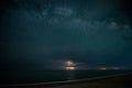 Starry night with thunderstorm and lightning over the sea Royalty Free Stock Photo