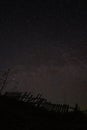 Starry sky above the silhouette of an old rickety fence