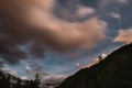 The starry sky with blurred motion colorful clouds and bright moonlight. Expansive night landscape in the European Alps, fisheye u