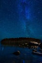 starry sky with constellations, galaxies, milky way and many stars above water of river with stones Royalty Free Stock Photo