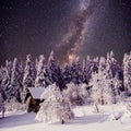 Starry sky and a tree in frost at the beautiful house in the woods in midwinter Royalty Free Stock Photo