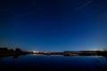 The stars in the night sky reflected in the river. The lights fr