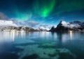 Stars and northern light. Aurora Borealis. Hamnoy village, Lofoten Islands, Norway. Glow on sky. Nature image. Mountains and water