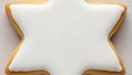 Starshaped cookie with white icing on a plain surface Royalty Free Stock Photo
