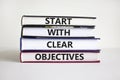 Start with clear objectives symbol. Books with words `Start with clear objectives`. Businessman hand. Beautiful white background