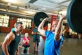 Start every week strong, finish every week stronger. a young man lifting weights while a group of people in the Royalty Free Stock Photo