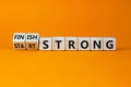 Start and finish strong symbol. Turned wooden cubes, changed words `start strong` to `finish strong`. Beautiful orange backgro
