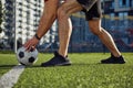 Male football player putting ball on strip line on center of soccer field