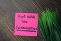 Start With The Fundamentals write on sticky notes isolated on office desk