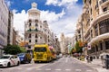 Start of the Gran Via with trucks and traffic at the traffic light and on the left the Grassy building, Madrid