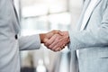 The start of a great journey. Shot of two unrecognizable businespeople shaking hands in an office at work.