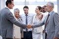 The start of a great working relationship. two businessmen shaking hands in front of their colleagues. Royalty Free Stock Photo