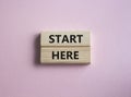 Start here symbol. Wooden blocks with words Start here Beautiful pink background. Business and Start here concept. Copy space Royalty Free Stock Photo