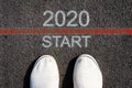 2020 Start. The inscription on the pavement. Two white sneakers. Top View. The concept of the beginning of the new year. Royalty Free Stock Photo
