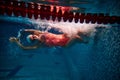 Start of move. Sportive woman, professional swimmer training in swimming pool indoor. Athlete in goggles and cap Royalty Free Stock Photo