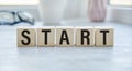 Start now or later symbol. Businessman turns wooden cubes and changes words Royalty Free Stock Photo